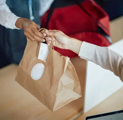 Cliente recebendo pedido para retirada do La Fleur Bistrô